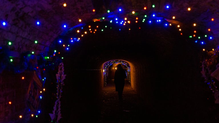 The tunnels at Calke Abbey, with multicoloured lights strung across the ceilings and down the walls.